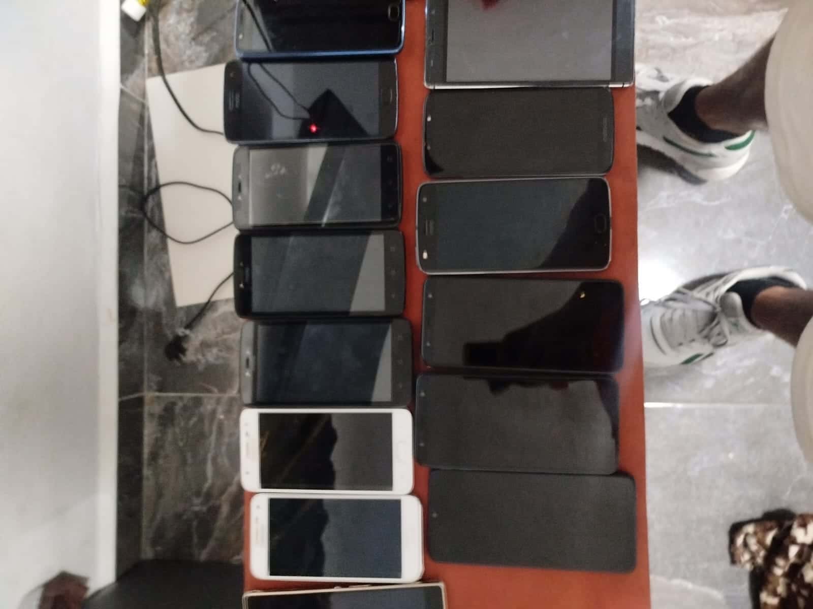 Celulares usados ordenados sobre una mesa antes de borrar sus datos y reciclarlos