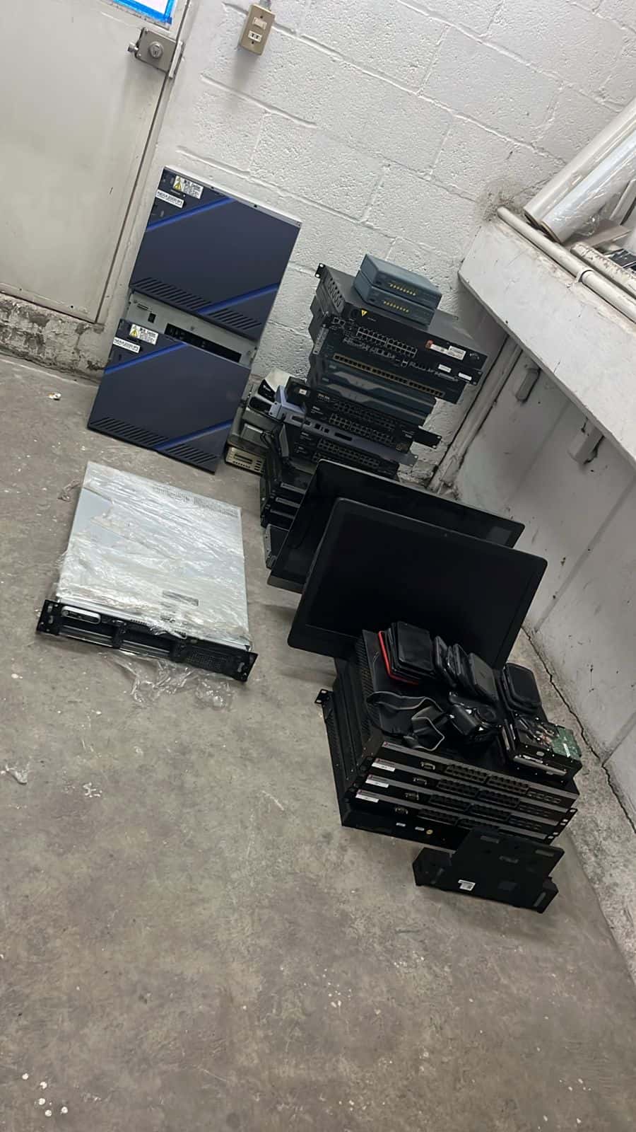 Servidores, monitores y switches reunidos en una oficina para su retiro