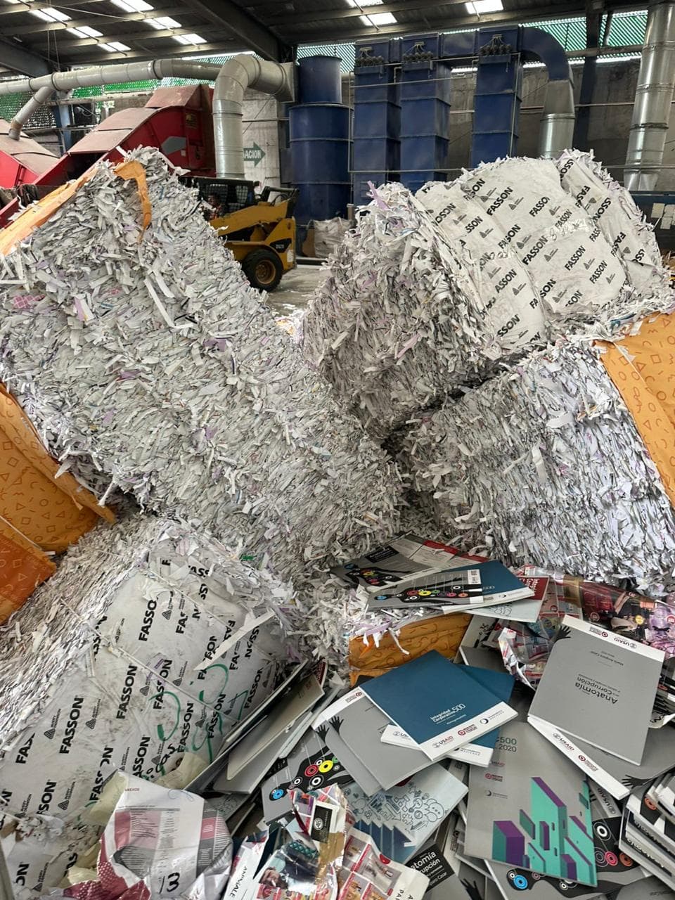 Pacas de papel triturado en una planta de reciclaje